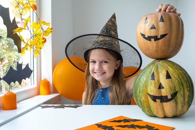 Kind hält zwei Kürbisse übereinander. Halloween-Dekorationskonzept