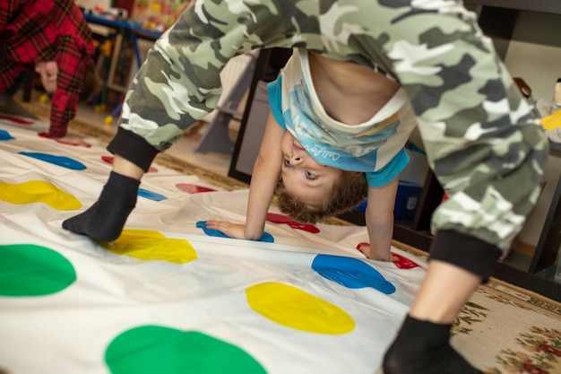 Kind hat Spaß beim Twister-Spiel zu Hause