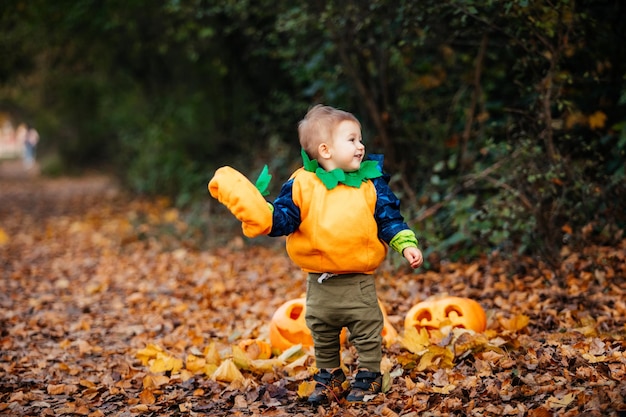 Kind im Kürbiskostüm, das den Park bei Helloween erkundet