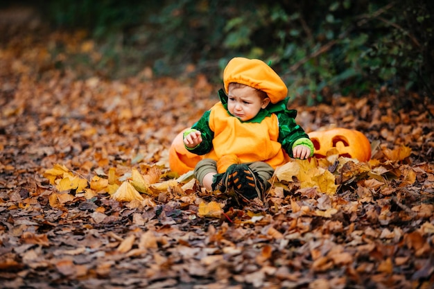 Kind im Kürbiskostüm, das den Park bei Helloween erkundet