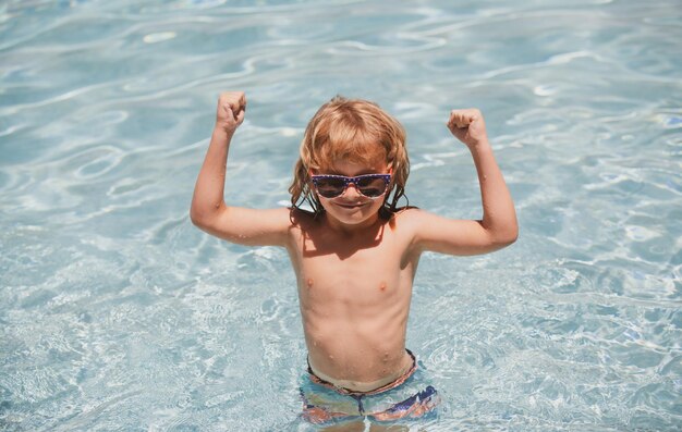 Kind im Schwimmbad aufgeregt süßer kleiner Junge mit Sonnenbrille im Pool an sonnigen Tagen