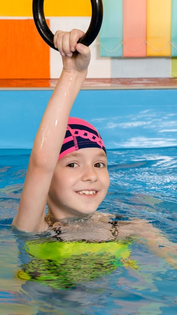 Kind im Schwimmbad mit Sportringen