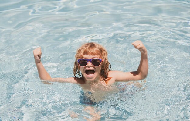 Kind im Sommerschwimmbad Aufgeregter süßer kleiner Junge mit Sonnenbrille im Pool an sonnigen Tagen