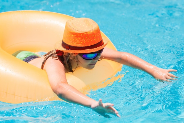 Kind im Swimmingpool auf aufblasbarem Ring Kindschwimmen mit orange Schwimmer Spaß am Strand für Kinder