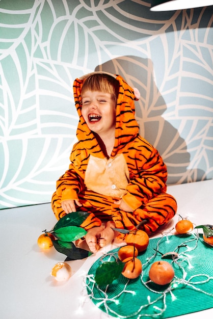 Kind im Tigerkostüm isst Mandarinen