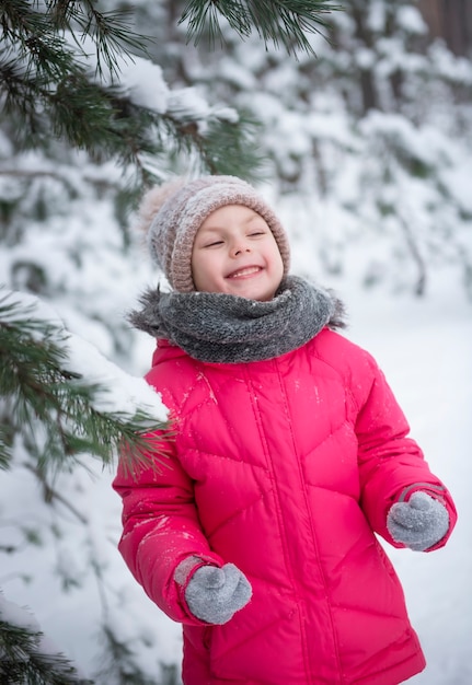 Kind im Winter. Ein kleines Mädchen, das draußen im Winter spielt. Ein schönes Winterkinderportrait. Glückliches Kind, Winterspaß im Freien.