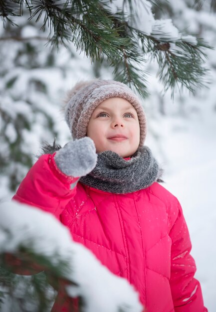 Kind im Winter. Ein kleines Mädchen, das im Winter draußen spielt. Ein schönes Winterkinderporträt. Glückliches Kind, Winterspaß im Freien.