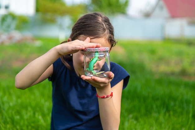 Kind in der Natur mit einer Eidechse. Selektiver Fokus