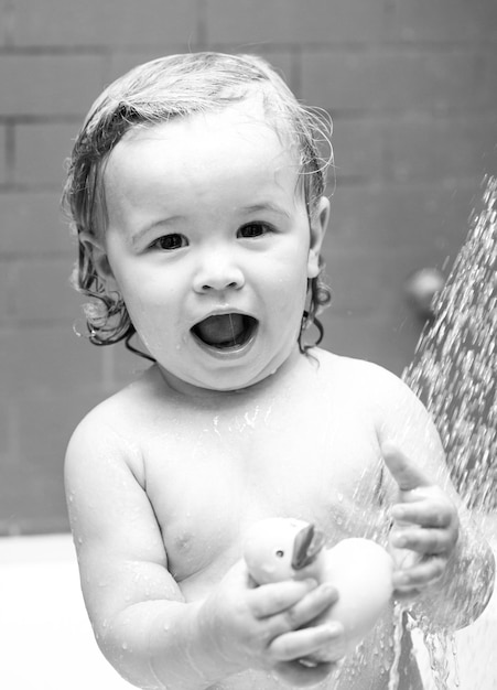 Kind in Dusche Baby badet in einem Bad mit Schaum und Seifenblasen