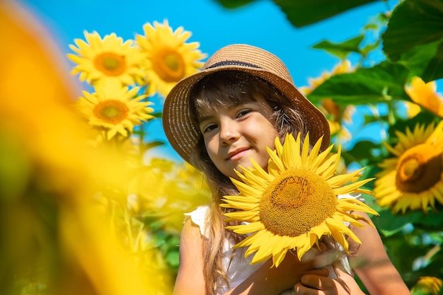 Kind in einem Sonnenblumenfeld. Selektiver Fokus. Natur.