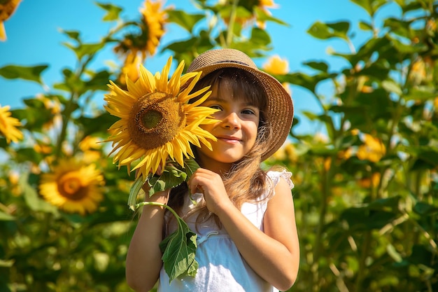 Kind in einem Sonnenblumenfeld. Selektiver Fokus. Natur.