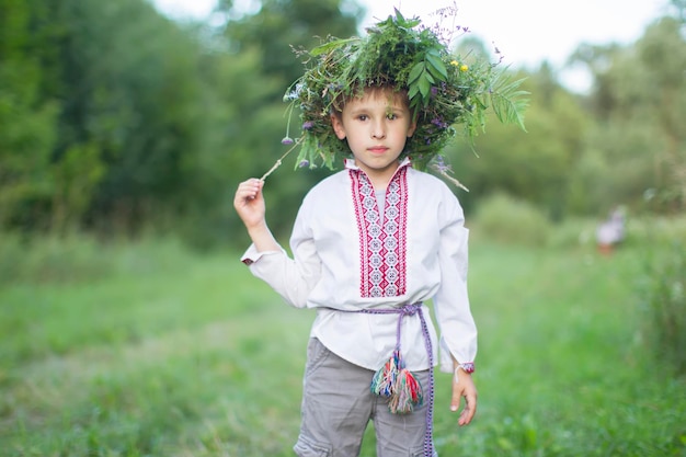 Kind in nationaler Kleidung mit einem Kranz auf dem Kopf Ukrainischer Junge Weißrussisch