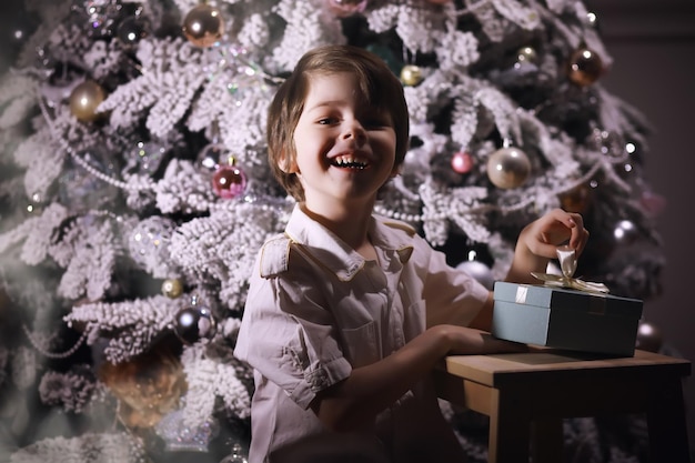 Kind in schicker Kleidung vor dem Weihnachtsbaum Silvester Warten auf das neue Jahr