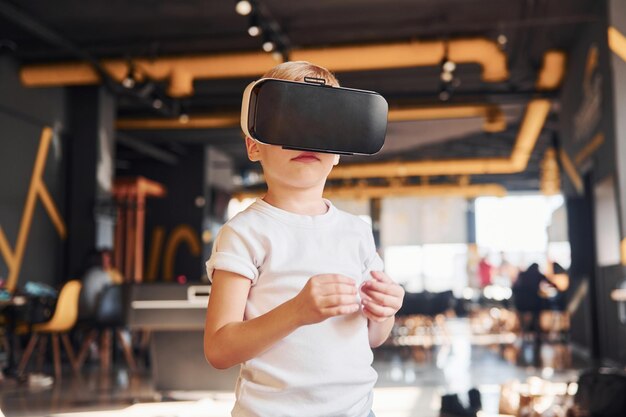 Kind in Virtual-Reality-Brille und Freizeitkleidung hat Spaß im Spielzimmer