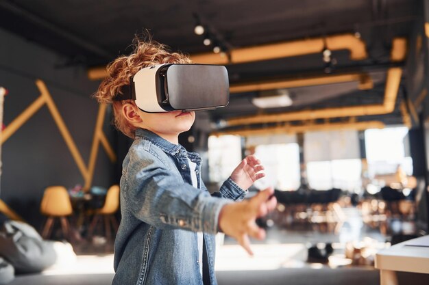 Kind in Virtual-Reality-Brille und Freizeitkleidung hat Spaß im Spielzimmer