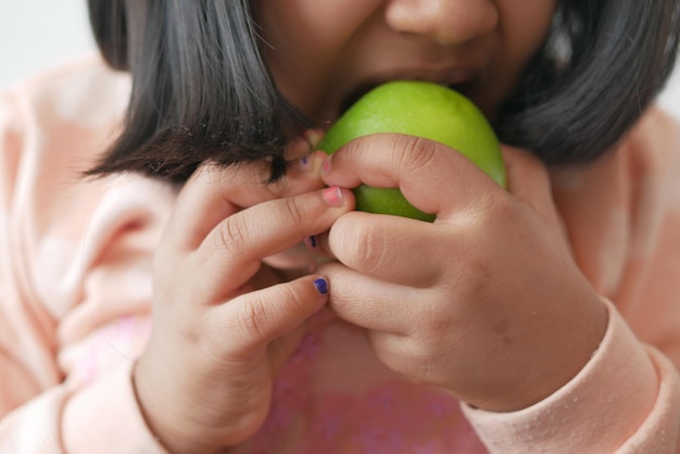 Kind isst Apfel aus nächster Nähe