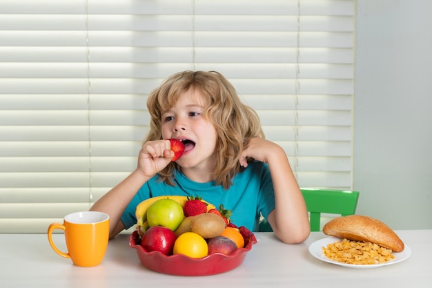 Kind isst Erdbeer-Bio-Früchte Lustiger Junge beim Frühstück Milchgemüse und Obst gesunde Ernährung für Kinder