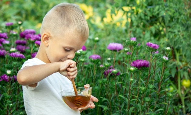 Kind isst Honig im Garten.
