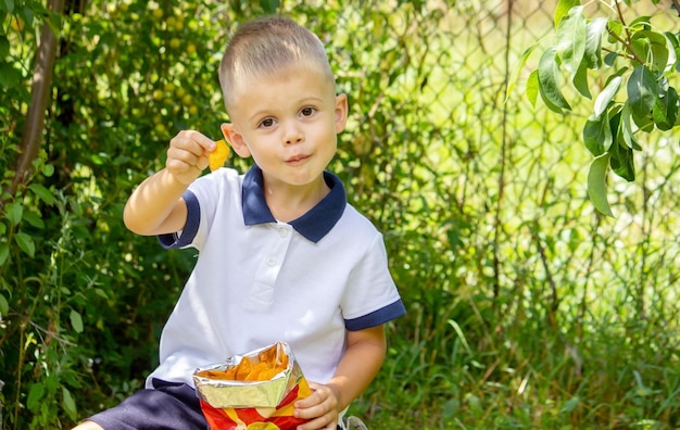 Kind isst Kartoffelchips. Selektiver Fokus