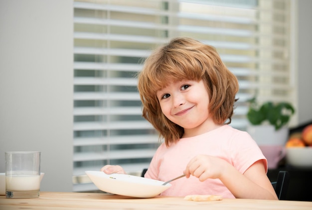 Kind isst kleinen gesunden hungrigen Jungen, der Suppe mit Löffel isst