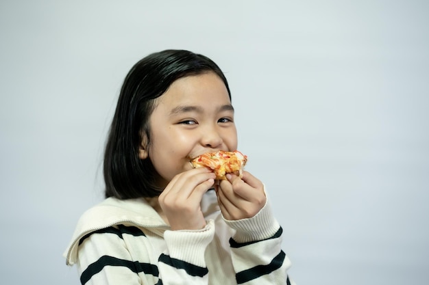 Kind isst Pizza auf weißem Hintergrund