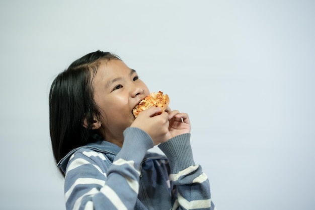 Kind isst Pizza auf weißem Hintergrund