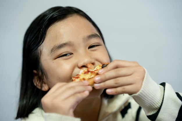 Kind isst Pizza auf weißem Hintergrund