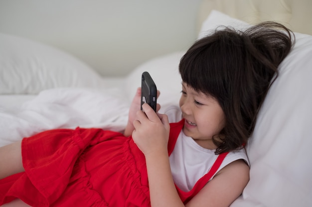 Kind ist süchtig nach Tablet, kleines Mädchen spielt Smartphone