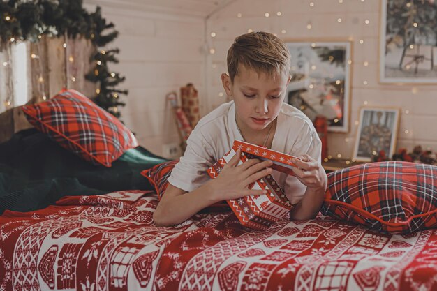 Kind Junge schmücken Weihnachtsbaum zu Hause Familie mit Kindern feiern Winterferien Kinder schmücken Wohnzimmer und Kamin für Weihnachten Schlafzimmer Neujahr Dekor