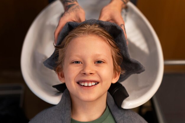 Foto kind lässt sich im salon die haare waschen