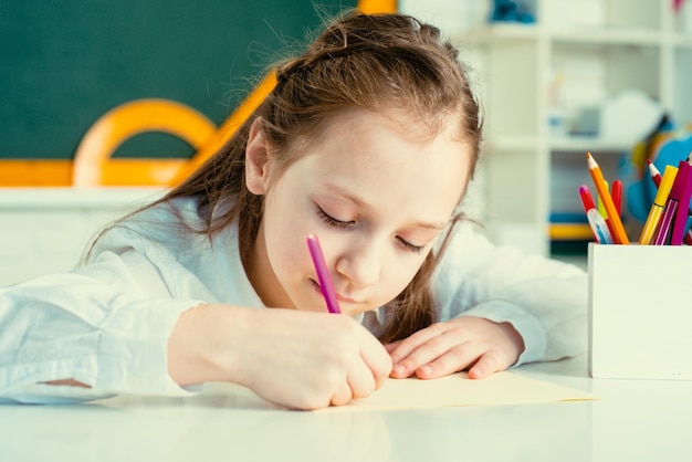 Kind lernt im Unterricht auf dem Hintergrund der Vorschulerziehung an der Tafel für Schüler