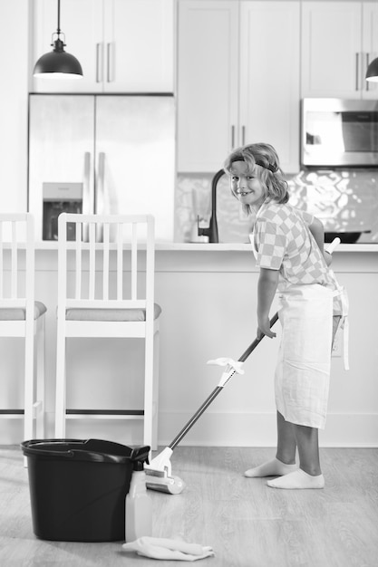 Kind macht Hausarbeit, putzt den Boden, Porträt eines Kindes, das bei Hausarbeiten hilft, das Haus putzt, Hausarbeit