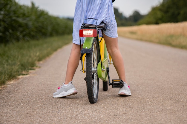 Kind Mädchen fährt Fahrrad auf dem Feld Wochenendausflug Reise