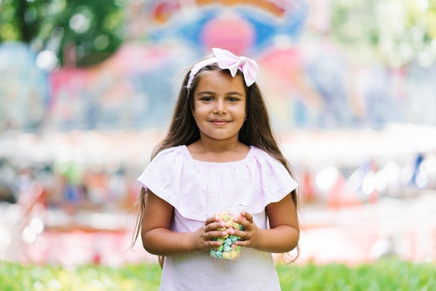 Kind Mädchen isst Popcorn in einem Vergnügungspark in den Sommerferien