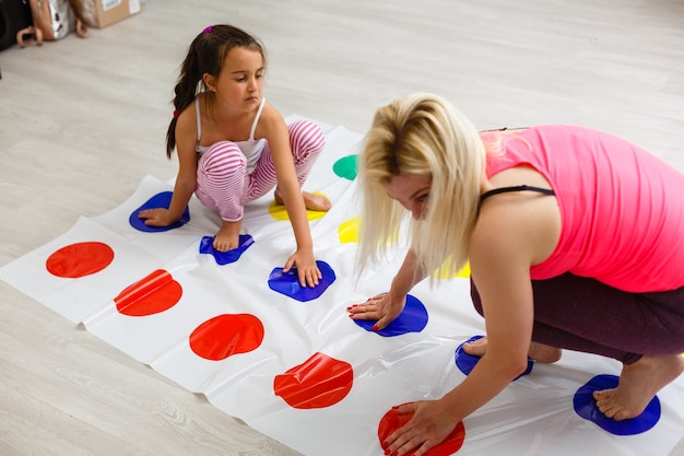 Kind Mädchen und Mutter spielen zusammen zu Hause