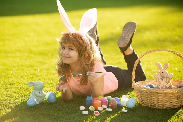 Kind mit auf Gras im Park Witz Ostereier Kinder feiern Ostern Malerei Eier Kind im Rabbi