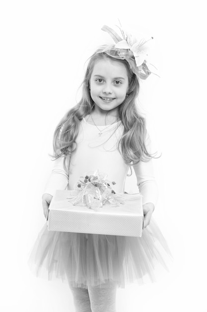 Kind mit Blüte in langem blonden Haar, isoliert auf weißem Mädchen, Ballerina, Lächeln mit Kiste in rosa Rock, Tutu, Geschenk oder Geschenk, Feiertag, Geburtstag, Jubiläum, Boxing-Tag-Konzept