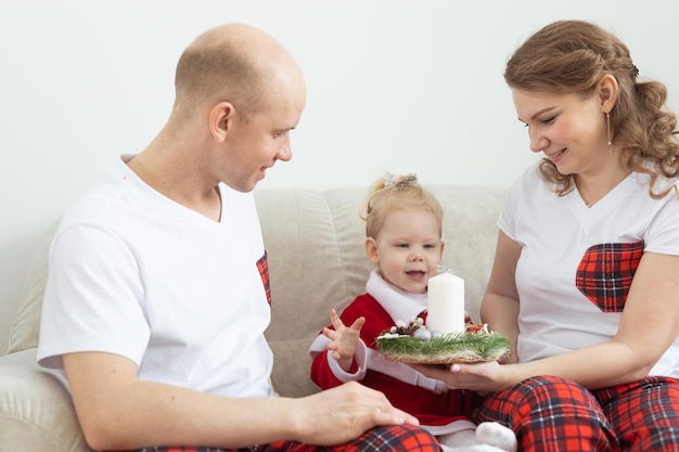 Kind mit Cochlea-Implantat-Hörgerät, das Spaß mit den Eltern in der Vielfalt des Weihnachtswohnzimmers hat