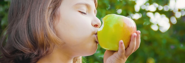 Kind mit einem Apfel. Foto. Natur