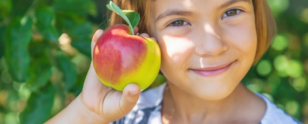 Kind mit einem Apfel im Garten