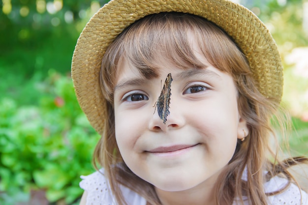 Kind mit einem Schmetterling. Idea leuconoe. Tiefenschärfe.