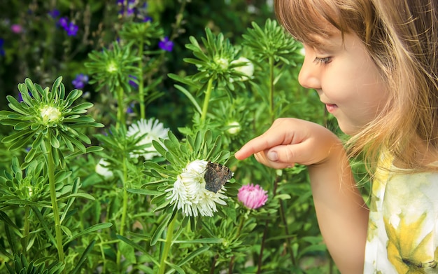 Kind mit einem Schmetterling in der Hand.