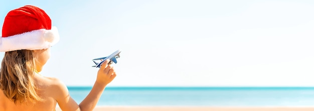 Kind mit Flugzeugen in der Hand am Strand