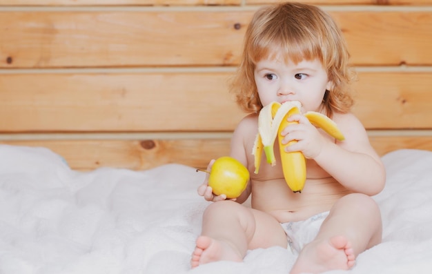 Kind mit frischem Obst Apfel und Banane feste Nahrung für frisches Gemüse und Obst für Säuglinge