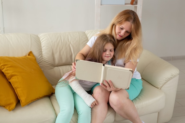 Kind mit gebrochenem Arm und Gips verbringen Zeit zu Hause mit der Mutter. Kinderkrankheiten, positiv