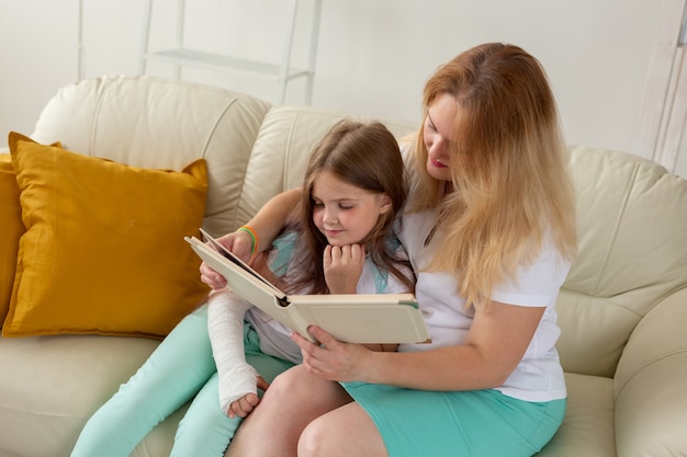 Kind mit gebrochenem Arm und Gips verbringen Zeit zu Hause mit der Mutter