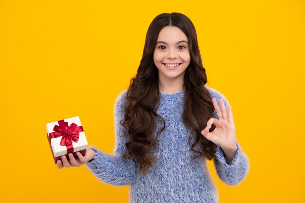 Kind mit Geschenkbox auf isoliertem Hintergrund Geschenke zum Geburtstag, Valentinstag, Neujahr oder Weihnachten Glücklicher Teenager, positive und lächelnde Emotionen von Teenager-Mädchen