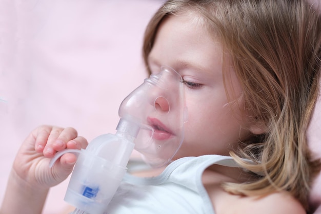 Kind mit Inhalatormaske atmet Probleme mit Asthma