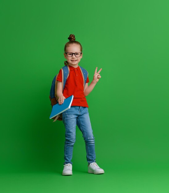 Kind mit Rucksack auf farbigem Hintergrund