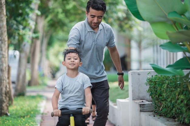 Kind mit seinem Vater lernt Fahrrad fahren